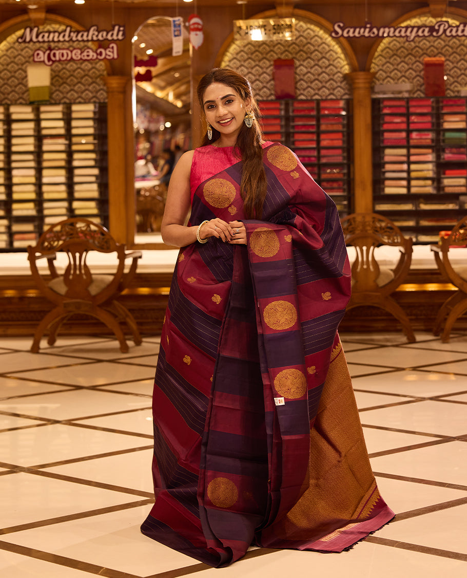 Graceful maroon and deep indigo colour kancheepuram silk saree adorned with classic gold zari polka motifs and elegant horizontal weaving, finished with a striking pallu and perfectly complemented by a blouse
