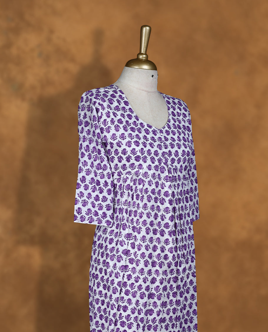 White colour Kurti featuring Purple floral print pattern across, round neckline with botton detail, and sleeves,
