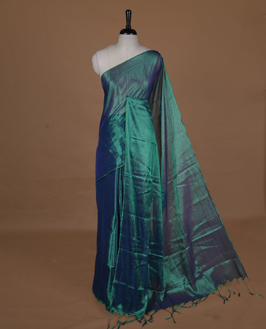 Peacock Green colour semi tissue saree featuring an elegant plain body, designed without a border and comes without a blouse piece.