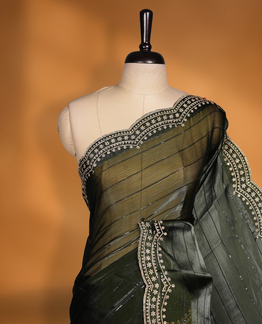 Dark olive green colour chiffon designer saree, featuring self colour beats stripes on body, heavy gold stone patttern on border and pallu, Paired with matching blouse.
