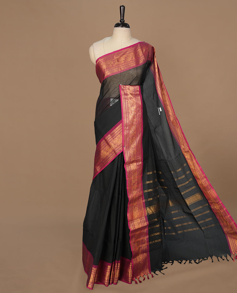 Black colour chettinad cotton saree featuring elegant plain body, complemented by contrast magenta colour with gold zari border, paired with matching blouse piece.