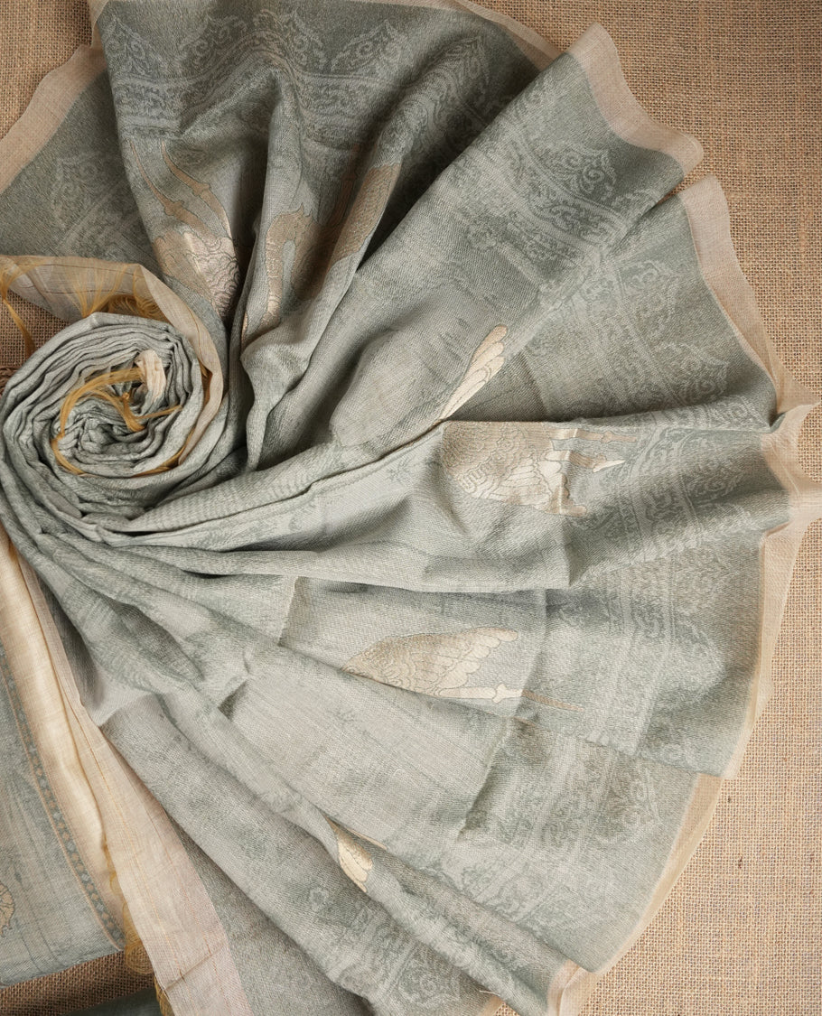 Beige & Pastel green colour suit material adorned with intricate woven patterns, bird print & subtle motifs, exuding ethnic grace & paired with a beautifully bordered dupatta and a matching plain bottom.