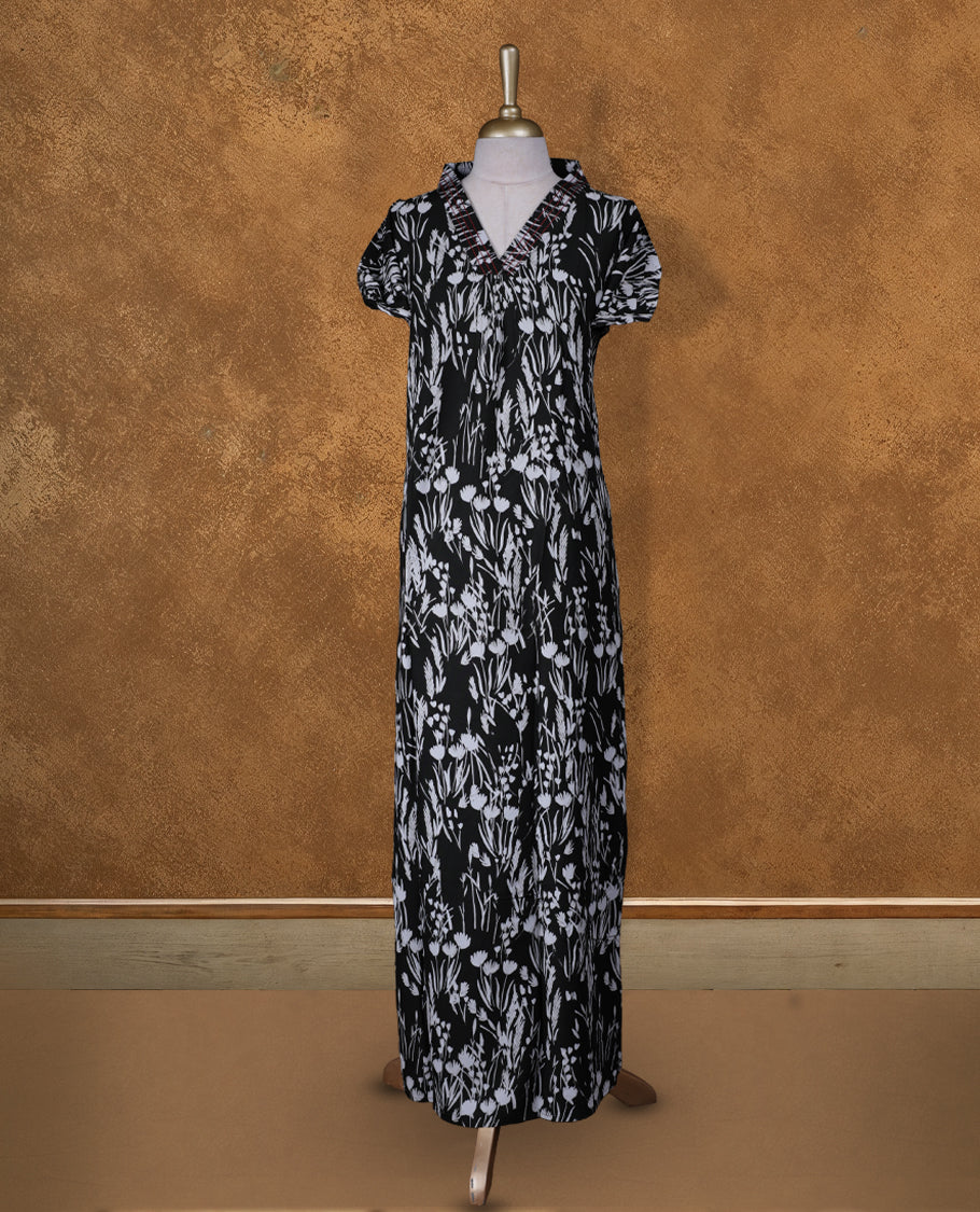Black colour NStyle nighty featuring White floral patterns, a V neckline with thread pattern, short sleeves, and a full ankle-length design.