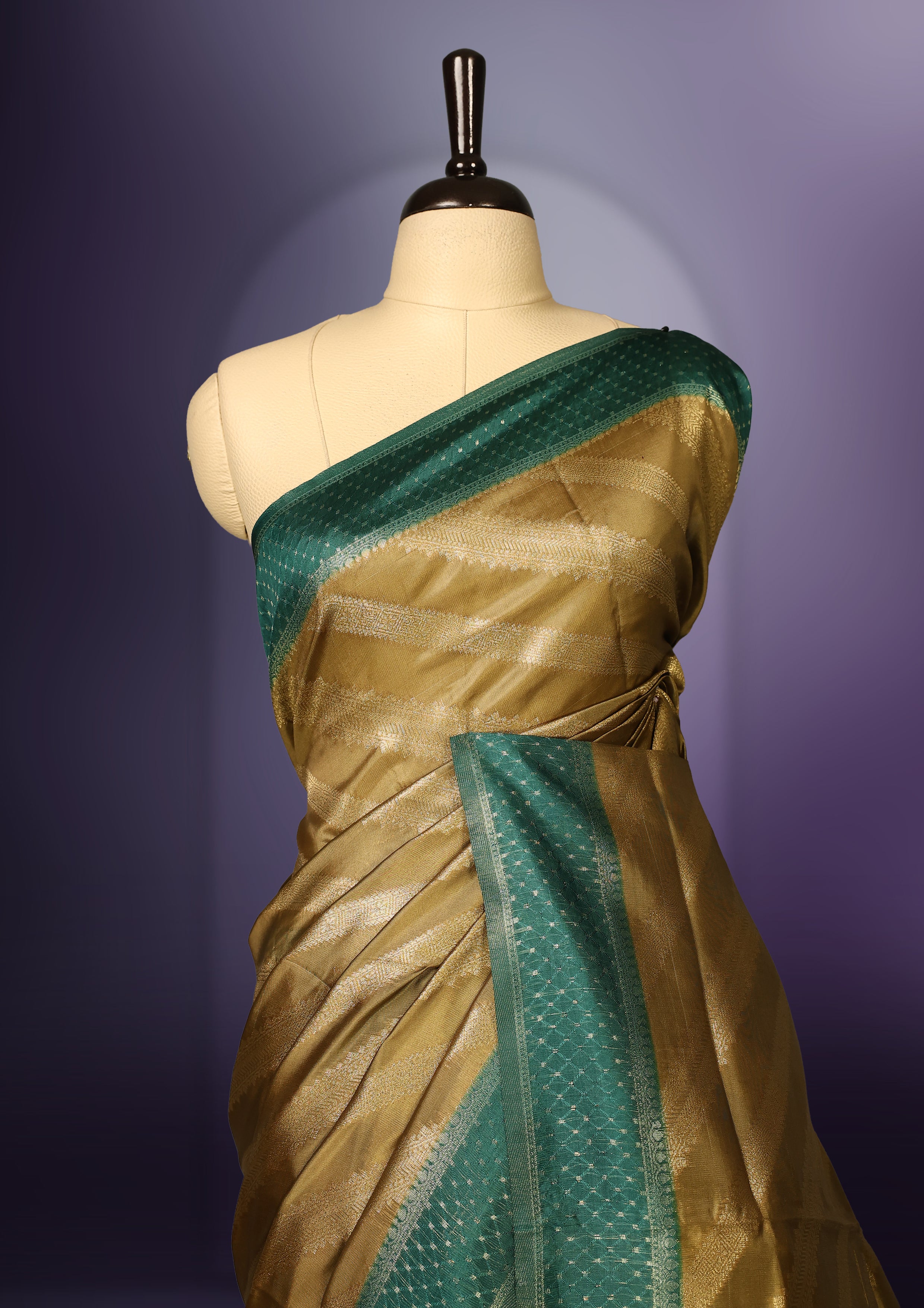 Golden saree featuring subtle self striped woven patterns on the body, enhanced with a green geometric border, complemented by a rich zari pallu with tassels, and paired with a matching blouse for a traditional elegant look.