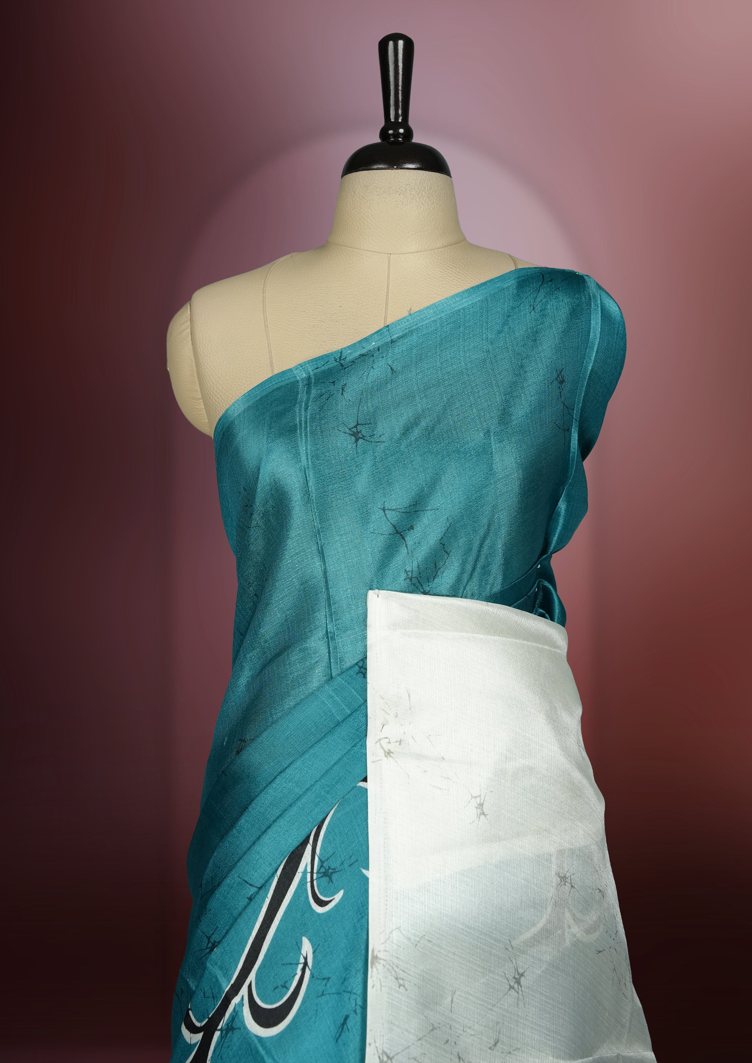 Teal blue colour saree adorned with bold off white floral prints, blending tradition with a modern twist & paired with a matching blouse.