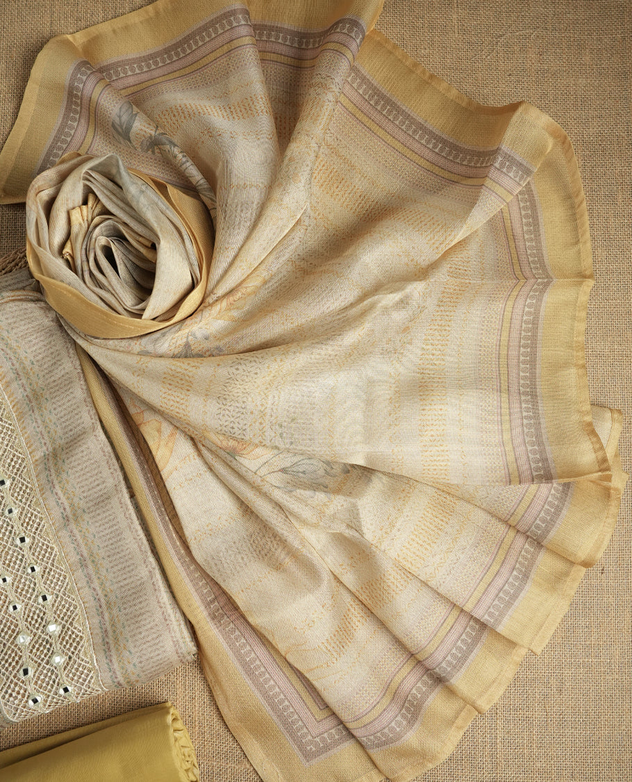 Pastel yellow and beige colour suit material with delicate woven mirror work patterns and subtle zari detailing & Includes a soft dupatta with a floral touch and plain matching bottom.