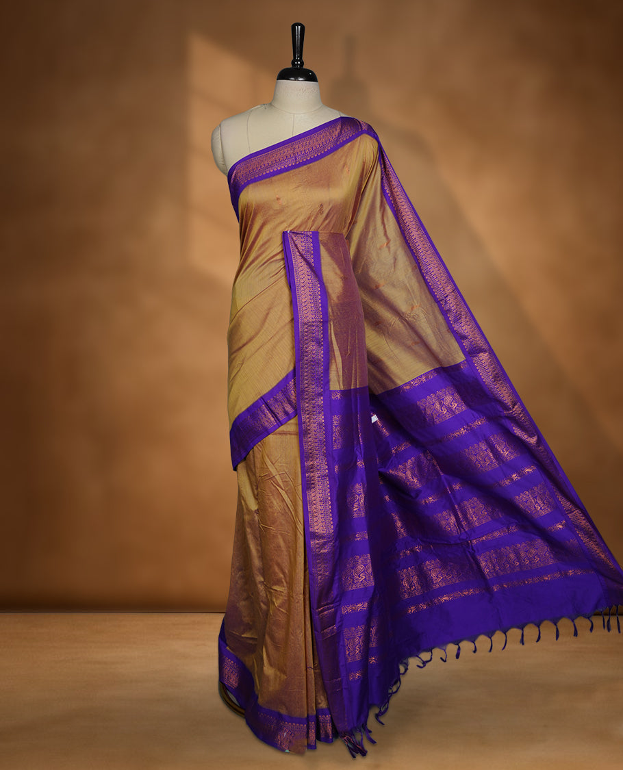 Antique gold colour Kalyani cotton saree featuring a plain elegant body, complemented by a rich Purple zari border and traditional woven pallu, paired with a matching blouse.