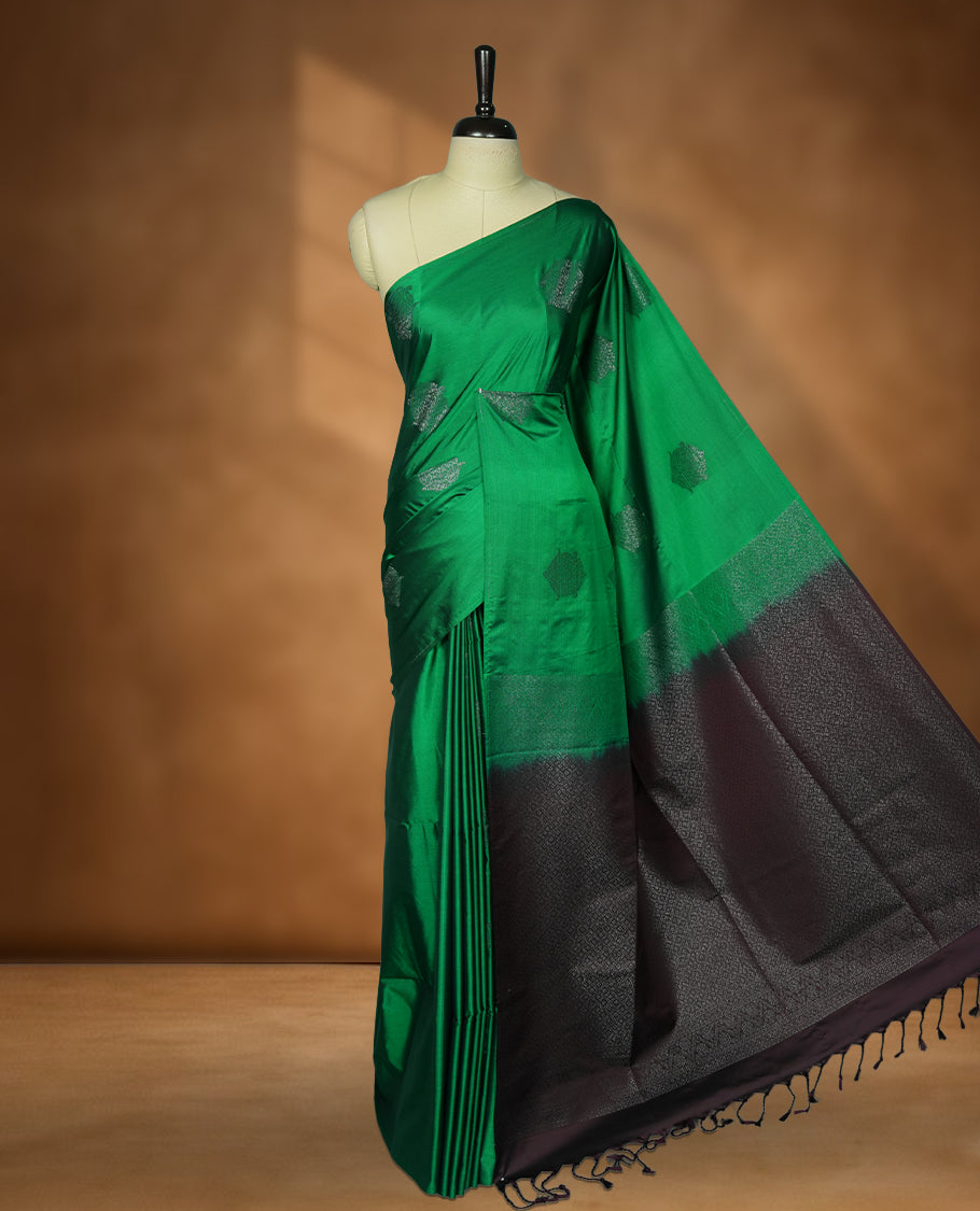 Green colour soft silk saree featuring Antique zari motifs on body with Highlighting contrast Deep Plum colour pallu and paired with matching blouse piece.