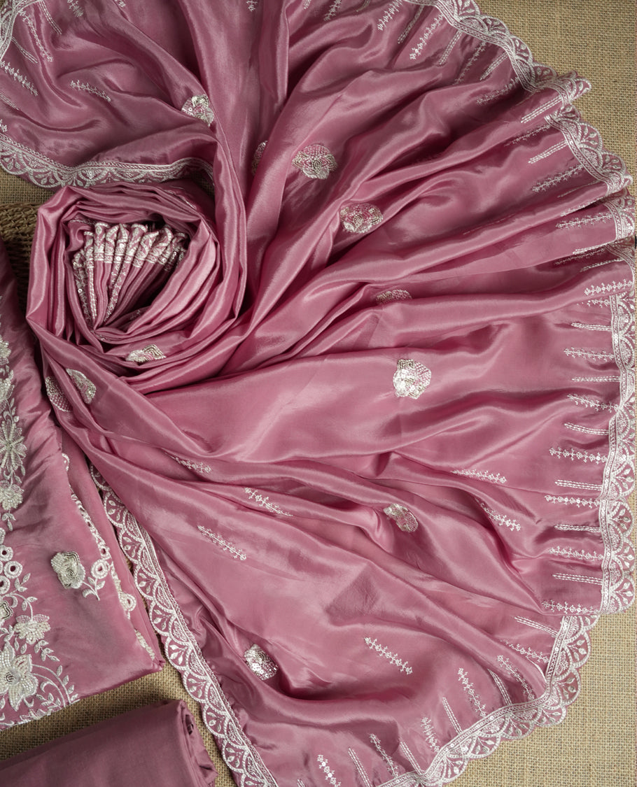 Dusty mauve colour suit material adorned with elegant white thread , cut beads & sequin embroidery, highlighted by a delicate lace border & Paired with a matching embroidered dupatta and plain bottom.