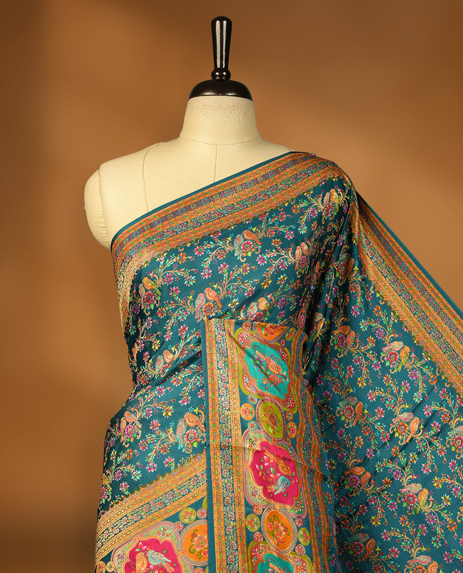 Crystal Teal blue colour Pashmina silk saree densely woven with intricate multicolour floral kodi pattern across the body, framed by an opulent arabesque border and grand storytelling pallu, paired with a matching woven border blouse piece
