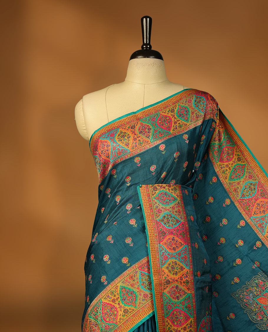 Dark teal blue colour Pashmina silk saree densely woven with intricate multicolour floral motifs across the body, framed by an opulent arabesque border and grand storytelling pallu, paired with a matching woven border blouse piece