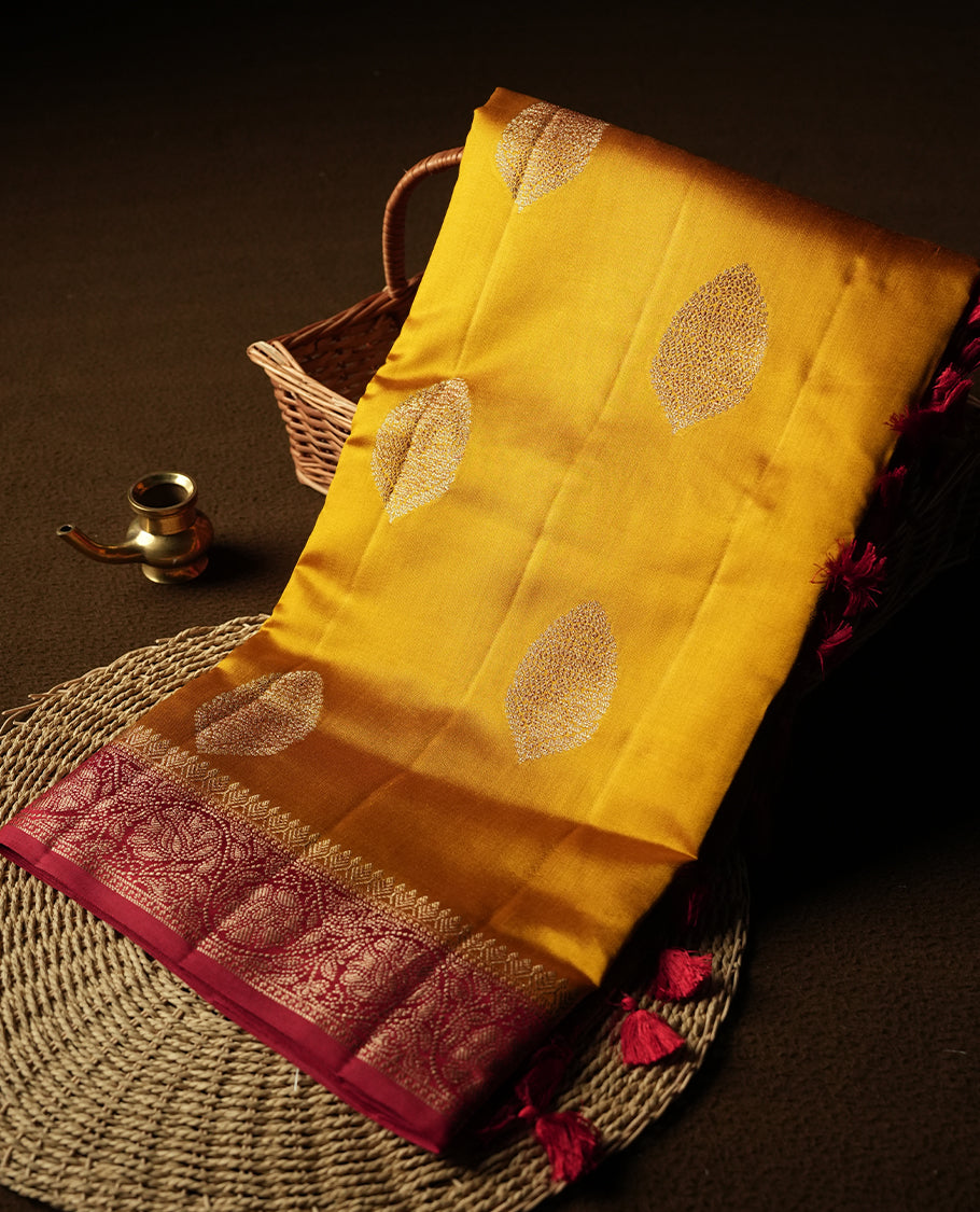 Golden Yellow Colour Banaras Soft Silk Saree with Gold Zari Oval Textured Buttas, Simple Decorative Pallu Border, Grand Pallu with Ornate Circular and Foliate Motifs in Red and Gold Tones, and Matching Red Blouse.