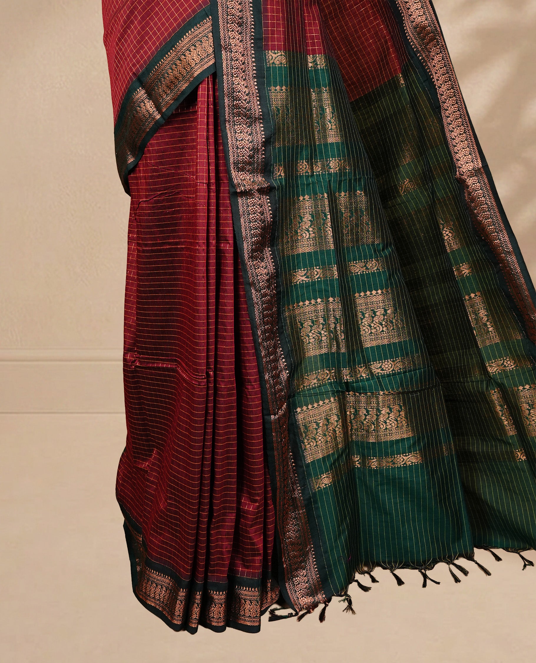 Maroon colour kalyani cotton saree featuring gold zari check pattern on body, complemented by green colour with Antique zari border, paired with matching blouse piece.