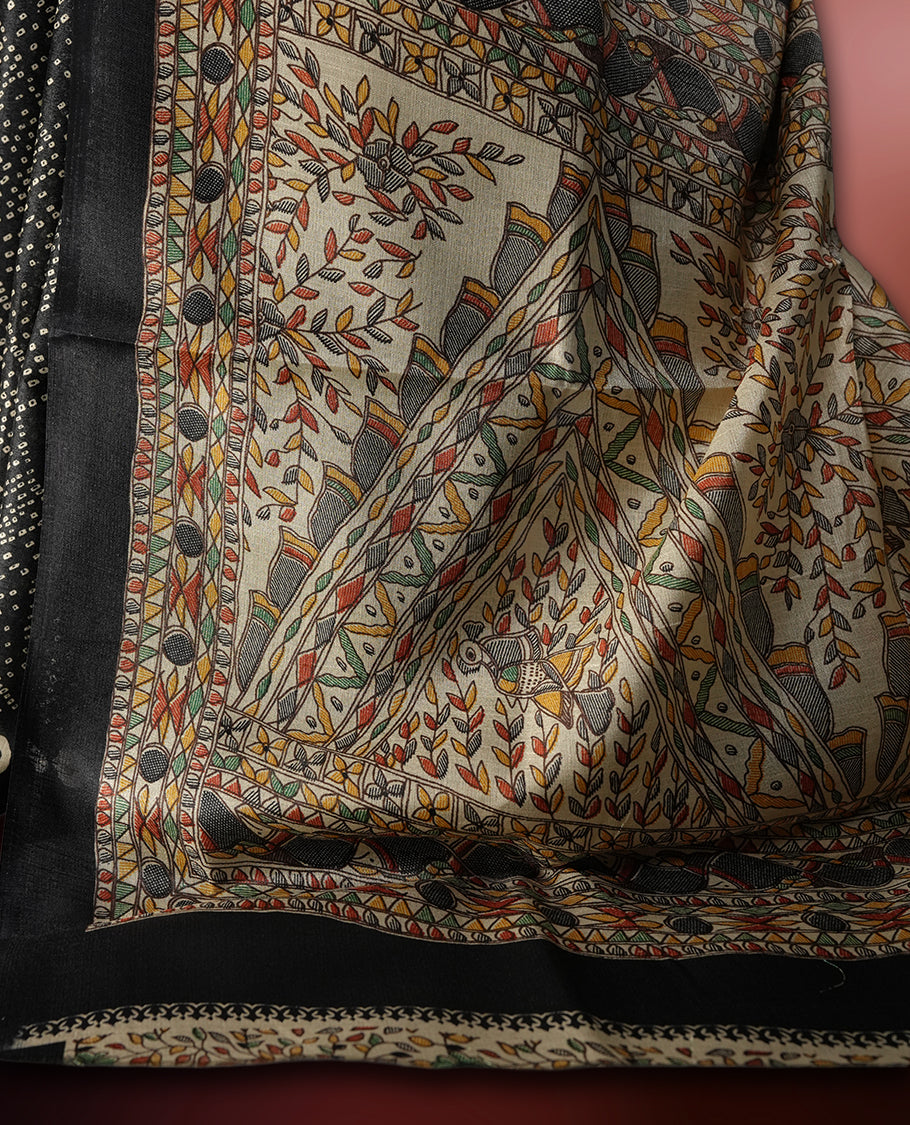 Black colour saree with intricate cream dotted patterns and a striking Madhubani inspired pallu, The soft fabric offers a graceful drape, making it perfect for festive and formal occasions, paired with blouse.