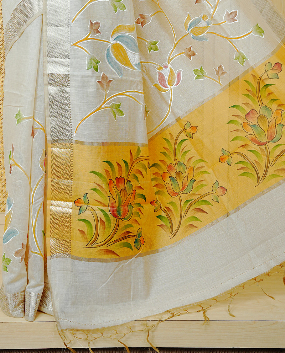 Cream Colour Tissue Kerala Saree Featuring Floral Kodi Threadwork Across The Body, Enhanced With A Light Gold Zari Border And A Yellow Floral Pallu, Finished With Gold Tassels And A Matching Blouse Piece