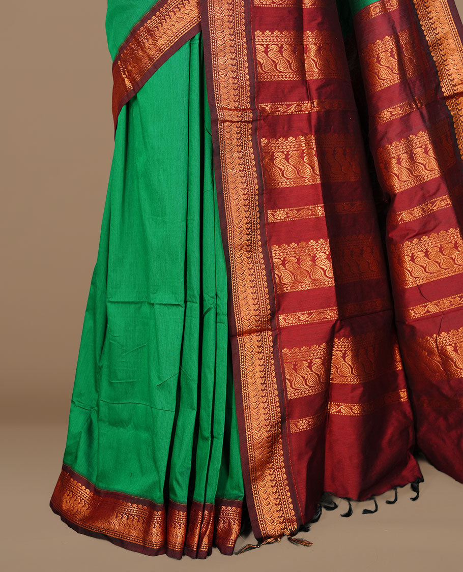Green colour kalyani cotton saree featuring antique zari motifs on body, complemented by Maroon colour with Antique zari border, paired with matching blouse piece.