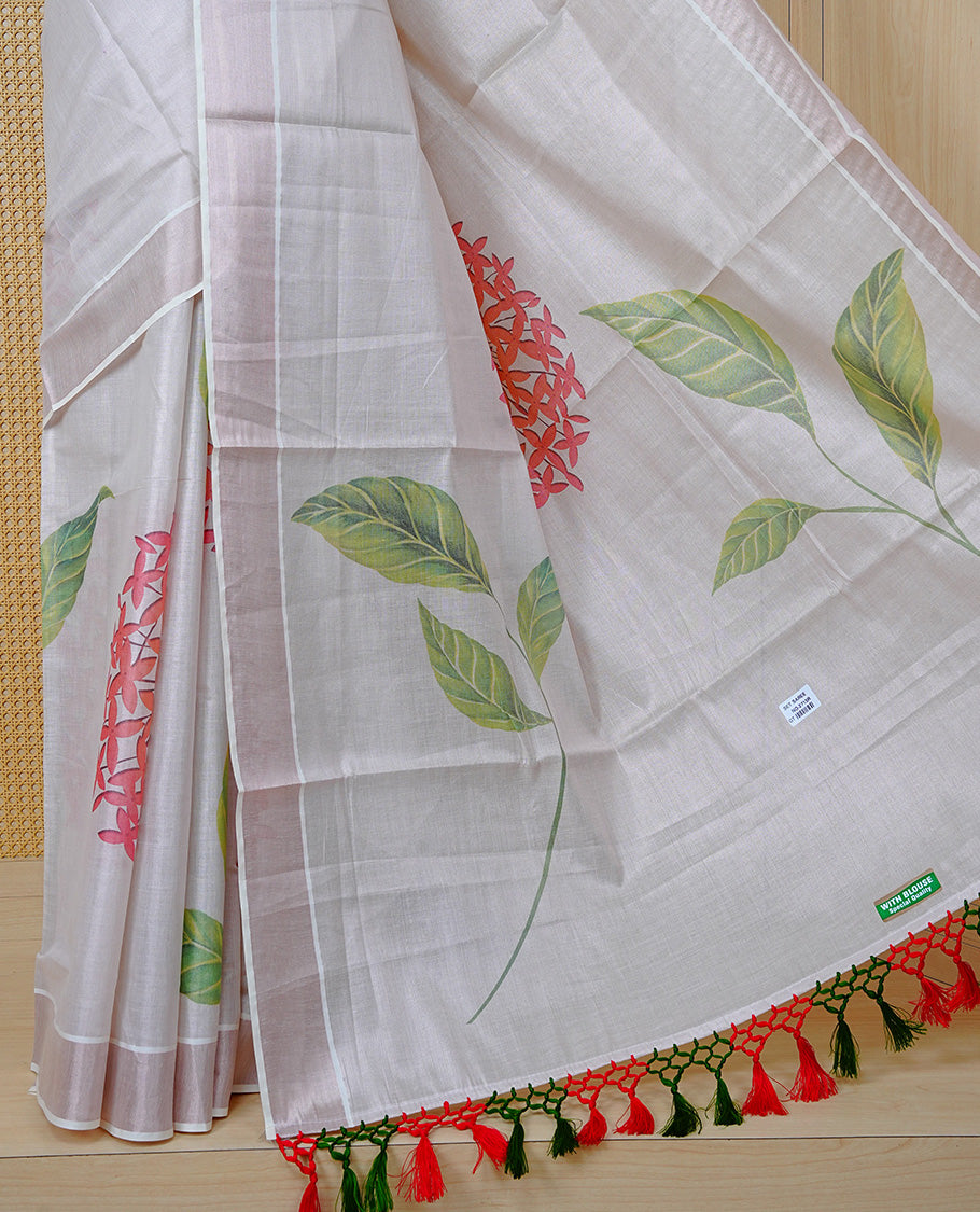 Cream Colour Tissue Kerala Saree Featuring A Digital Floral Printed Body & Pallu, , Beautifully Enhanced With A Classic Rose Gold Zari Border And Red & Green Tassels, Paired With A Matching Blouse Piece.