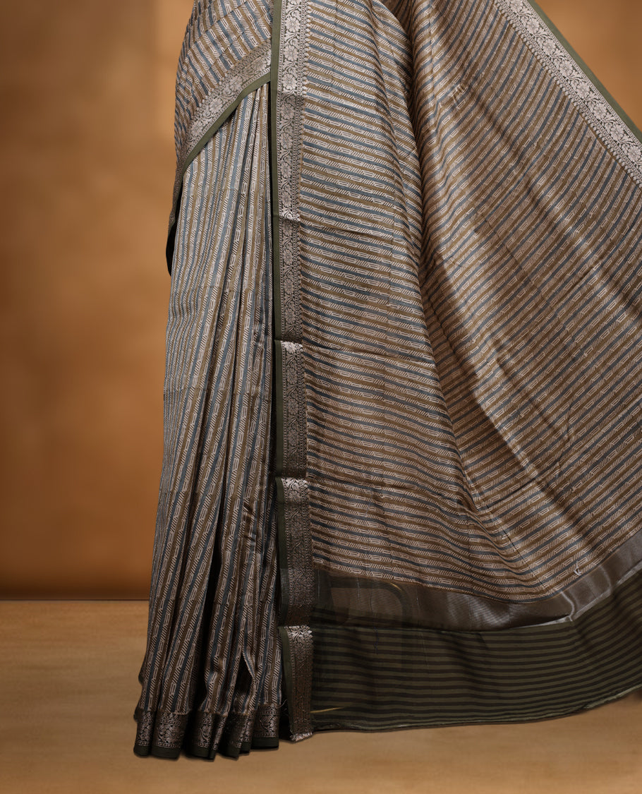 Cream colour chanderi silk saree with Olive & blue geometric stripped printed On body, compilmented by contrast olive colour border with golden zari floral pattern and a matching blouse.