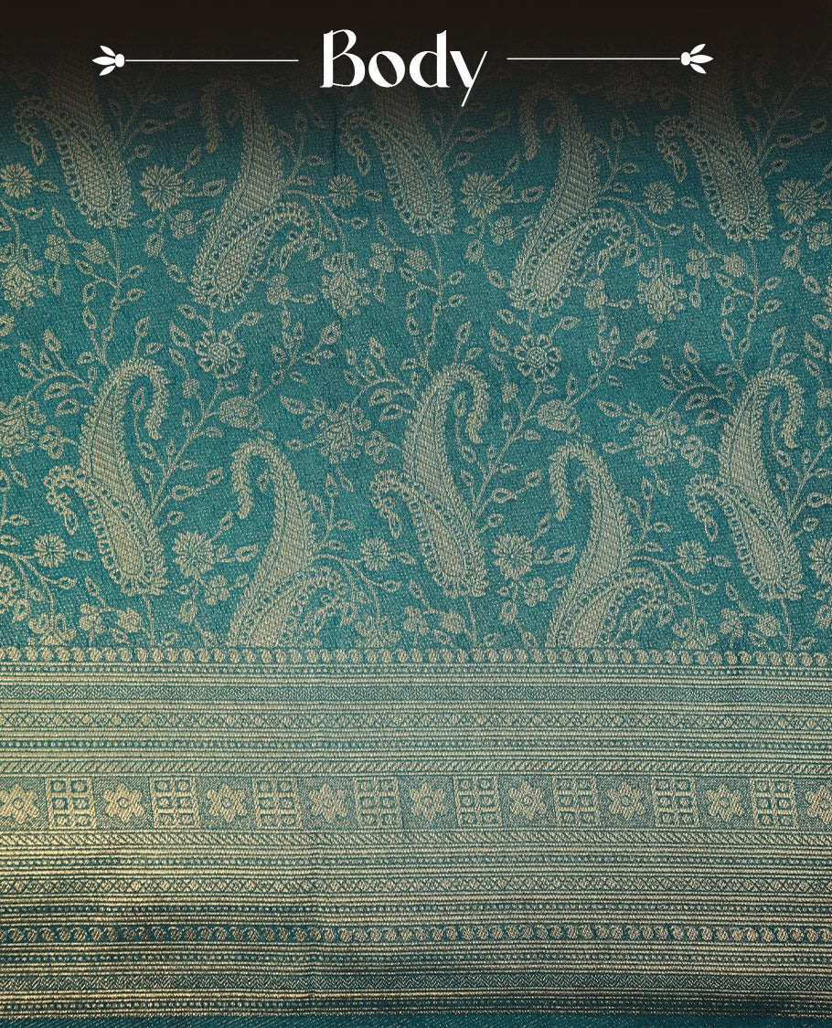 Peacock blue colour semi soft silk brocade saree featuring elegant gold zari floral and paisley motifs across the body, finished with a richly woven self-colour border and pallu, paired with a matching blouse.
