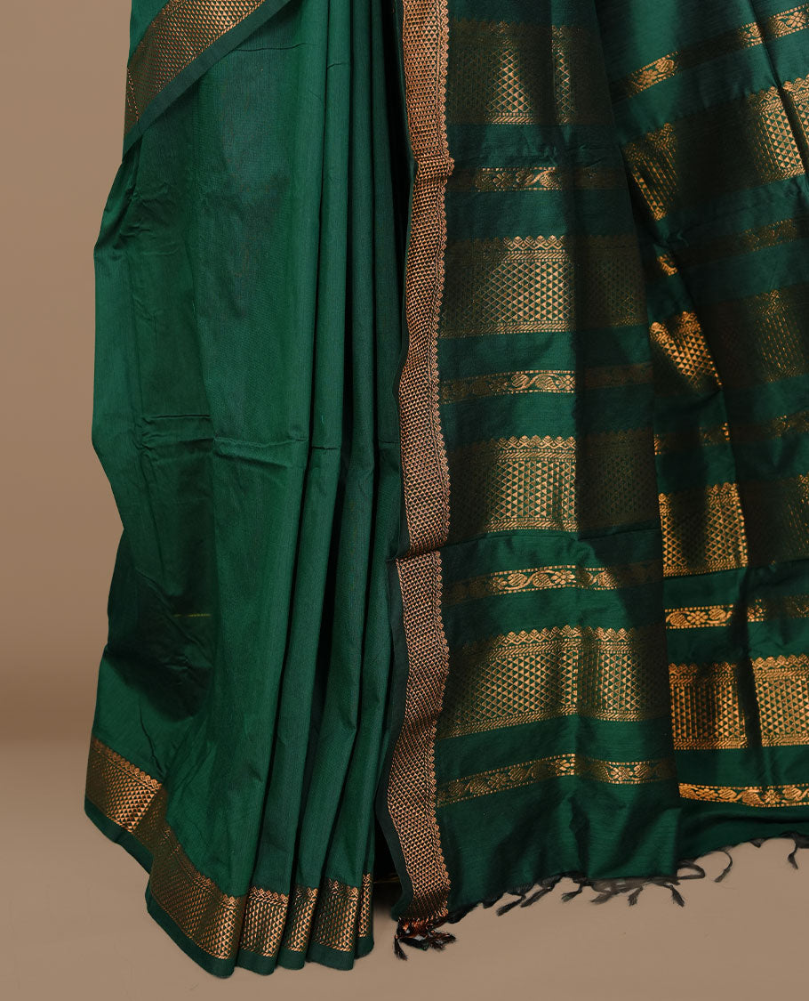 Dark green colour kalyani cotton saree featuring gold zari motifs on body, complemented by selfcolour with Antique zari border, paired with matching blouse piece.