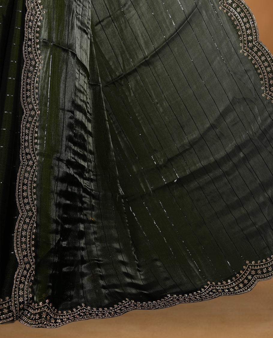 Dark olive green colour chiffon designer saree, featuring self colour beats stripes on body, heavy gold stone patttern on border and pallu, Paired with matching blouse.