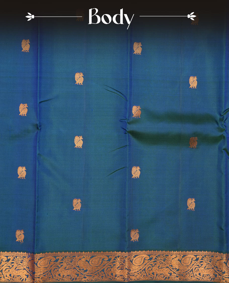 Peacock blue pure traditional Kancheepuram silk saree adorned with gold zari peacock motifs across the body, featuring elegant traditional borders with animal motifs, beautifully paired with a matching blouse piece.