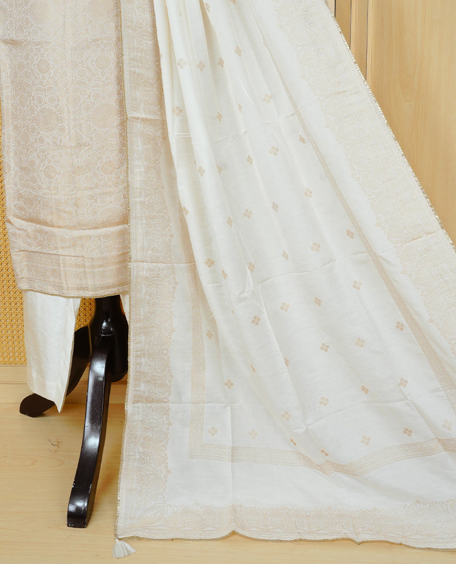 Cream colour churidar set featuring an all-over woven floral pattern and an intricately embellished neckline, paired with matching solid pants and a woven dupatta.