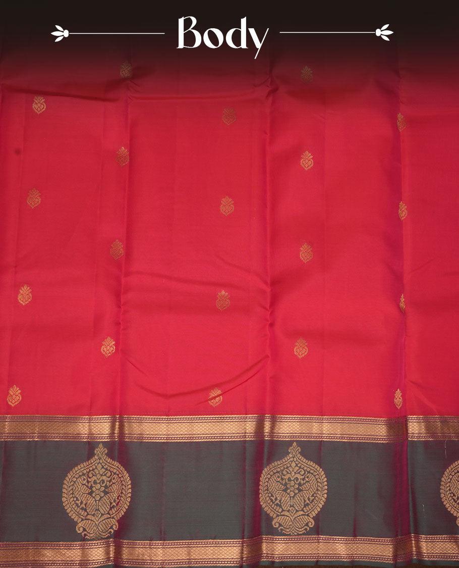 Reddish pink colour vasundhara silk saree featuring zari buttas on body, complemented by contrast green with zari border, paired with matching blouse piece.