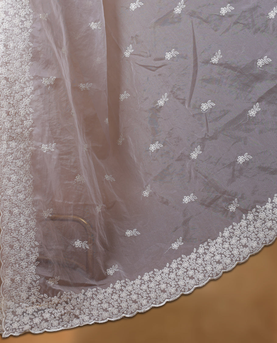 Cream colour organza designer saree featuring a subtle self patterned body and an intricately scalloped floral thread embroidered border all around, complemented by a coordinating embroidered pallu and paired with a matching blouse.