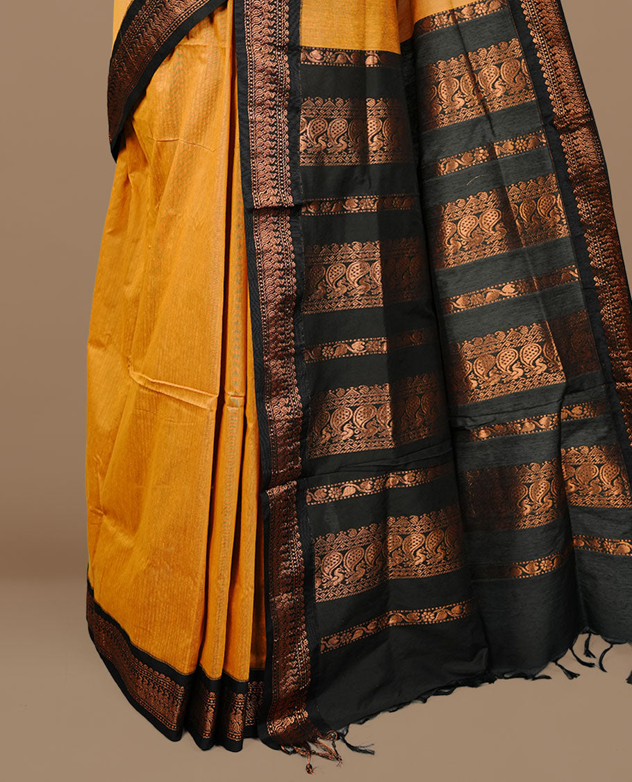 Mustard colour kalyani cotton saree featuring Elegant plain body, complemented by Black colour with Antique zari border, paired with matching blouse piece.