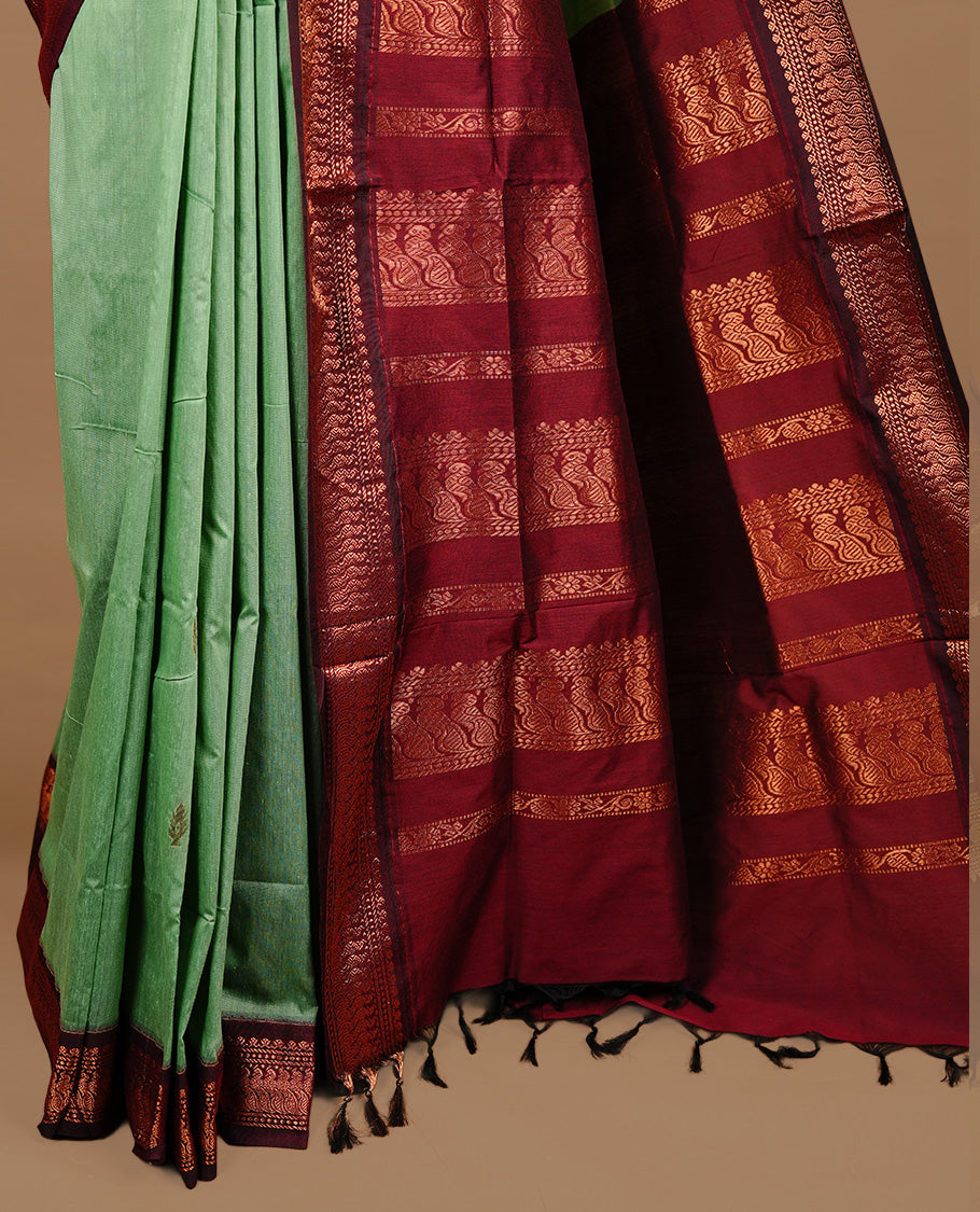 Pista green colour kalyani cotton saree featuring gold zari motifs on body, highlighting contrast Maroon colour with Antique gold zari border, paired with matching blouse piece.