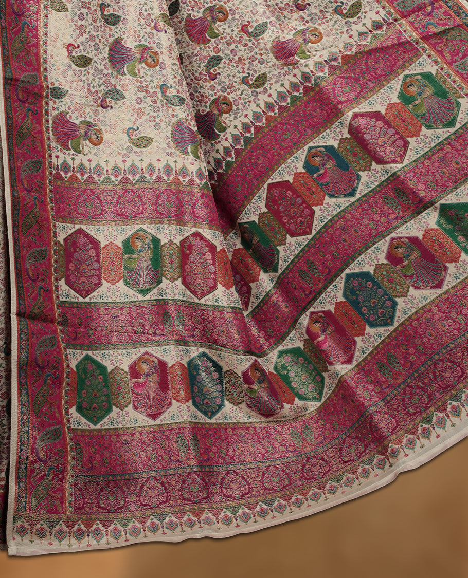 Ivory colour Pashmina silk saree richly woven with all over multicolour dancing figurines and paisley motifs, highlighted by a vibrant pink & green zari border and grand panelled pallu, paired with a matching woven border blouse piece.