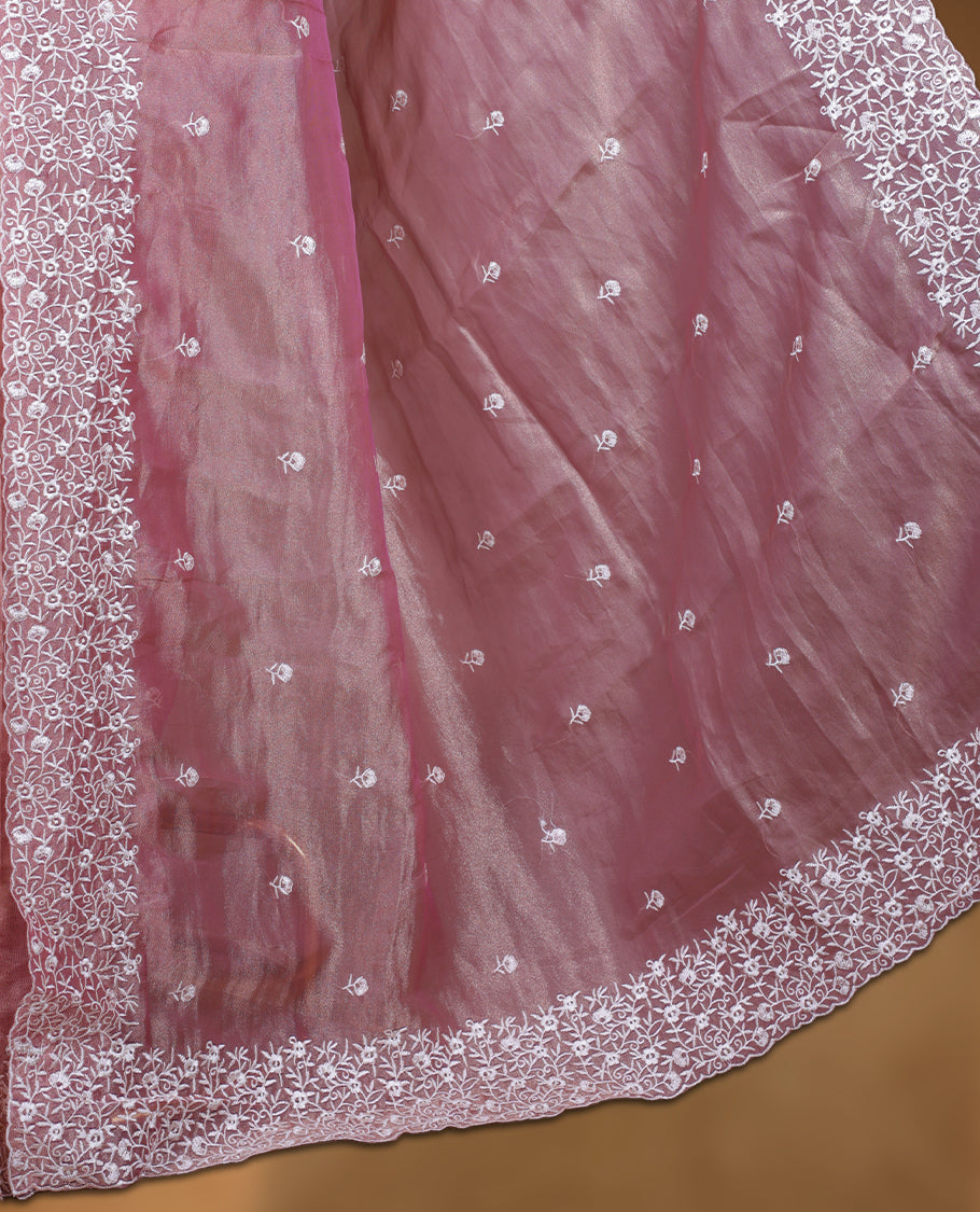 Pink colour net organza designer saree featuring a subtle self patterned body and an intricately scalloped floral thread embroidered border all around, complemented by a coordinating embroidered pallu and paired with a matching blouse.