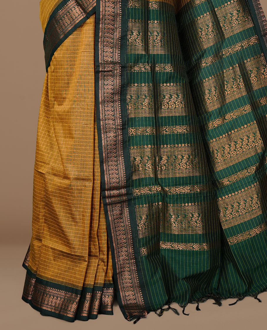Mustard colour kalyani cotton saree featuring gold zari check pattern on body, complemented by green colour with Antique zari border, paired with matching blouse piece.