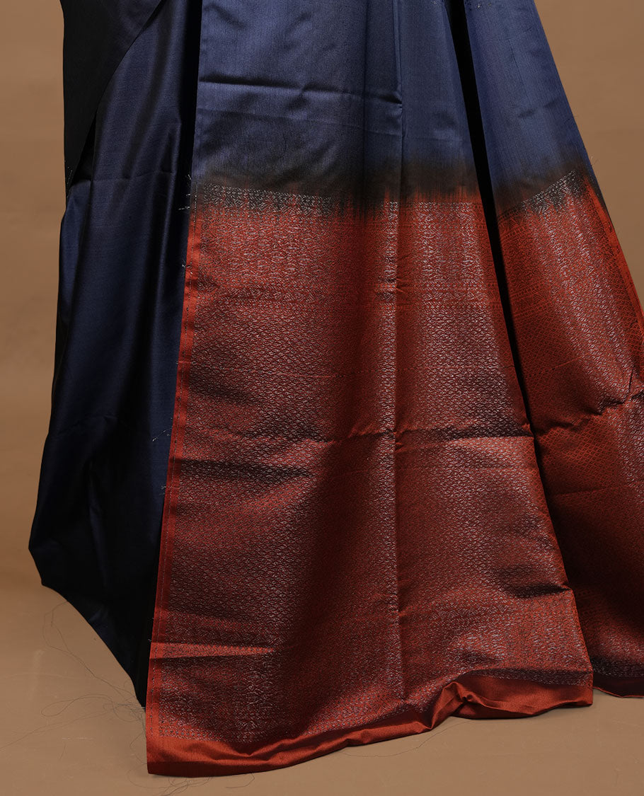 Navy blue colour soft silk saree features a sleek borderless design with intricate antique zari motifs, flowing into a striking contrast rust orange pallu and a matching blouse piece.