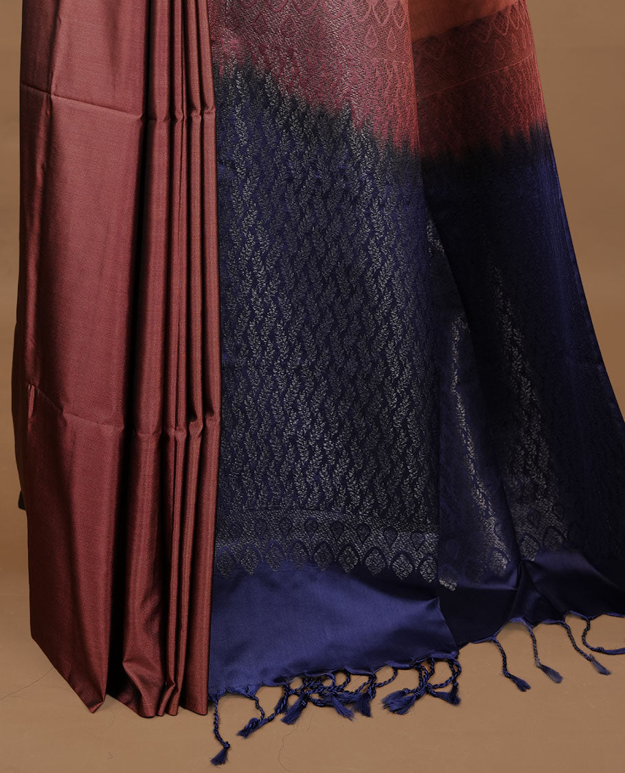 Brown colour soft silk saree features a sleek borderless design with intricate antique zari motifs, flowing into a striking contrast blue pallu and a matching blouse piece.