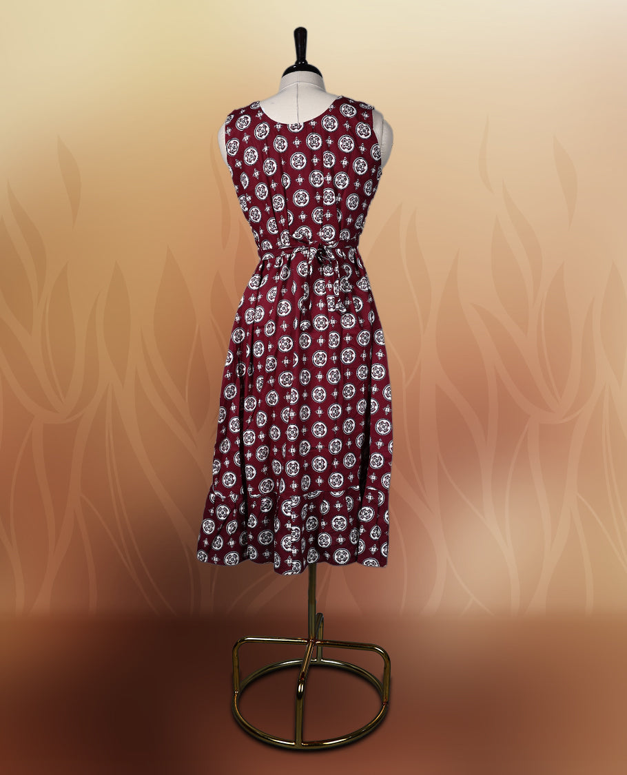Dark maroon colour sleeveless nightwear with intricate beige and black floral prints in circular patterns, Designed with a V neckline, this kurthi comes with matching fabric sleeves included for a versatile look.