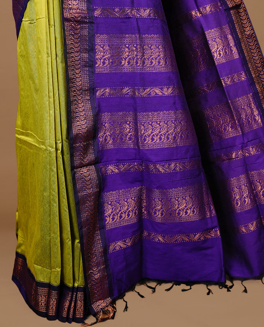 Green colour kalyani cotton saree featuring gold zari motifs on body, highlighting contrast Indigo colour with Antique gold zari border, paired with matching blouse piece.