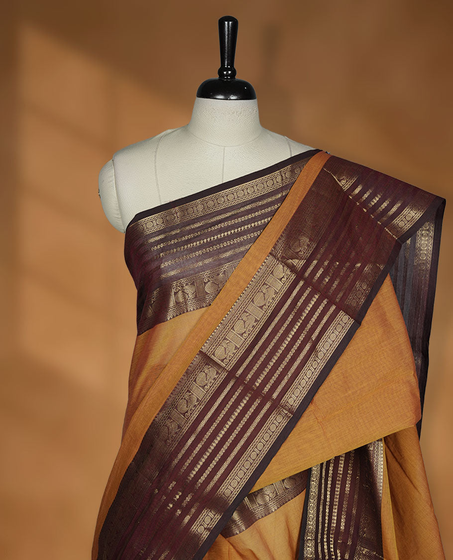 Dusty orange colour chettinad cotton saree featuring plain body, paired with a choclate brown colour traditional gold zari border paired with matching blouse.