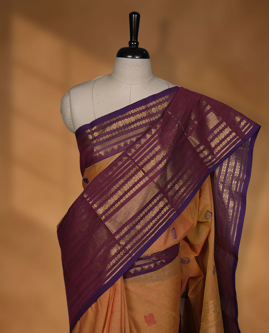 Dusty orange colour chettinad cotton saree featuring Purple colour motifs on body, contrast purple colour border with gold zari border, pallu and paired with matching blouse.