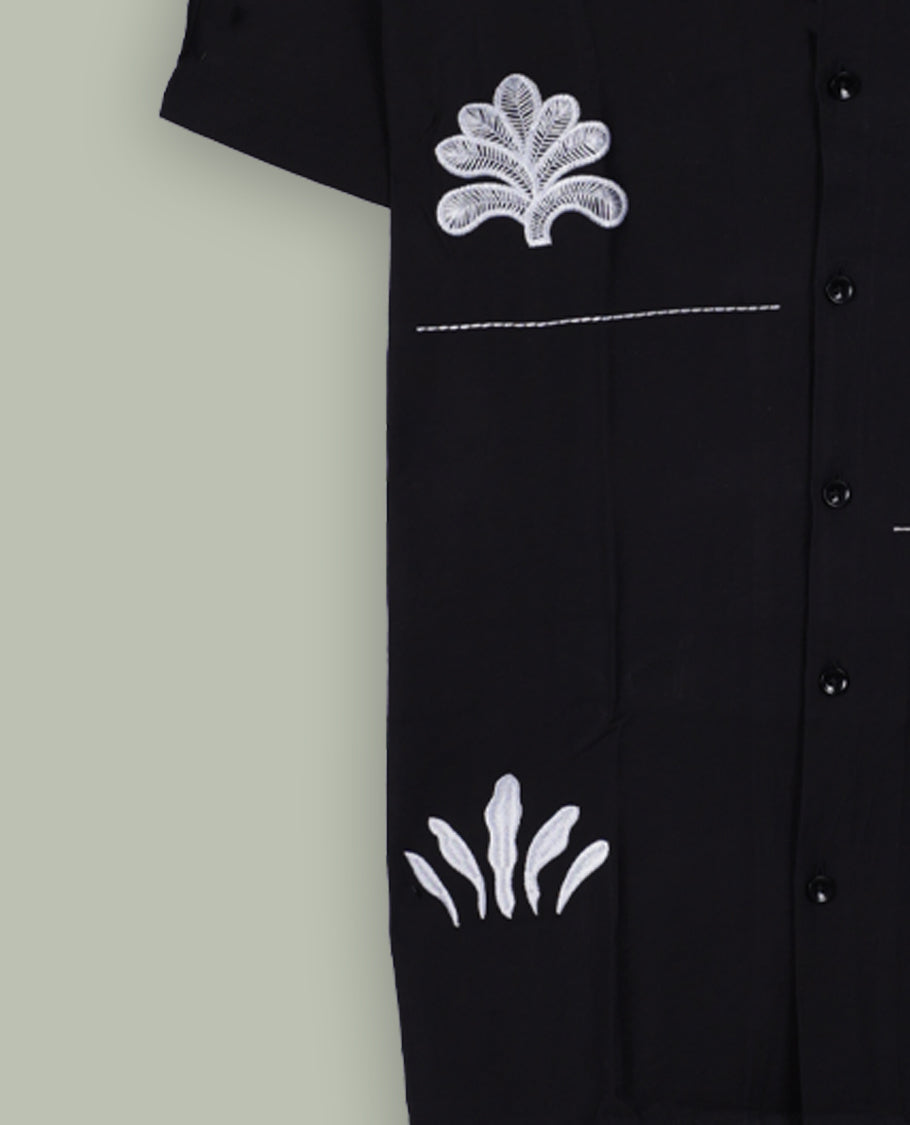 Black colour shirt featuring elegant white embroidery motifs on the body, Designed with a classic shirt collar and short sleeves, it blends contemporary style with subtle detailing.