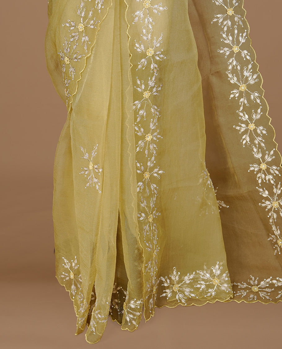 Pastel olive colour crush organza saree featuring gold thread floral and stone worked body, highlighting scalp designed border, paired with matching blouse piece.