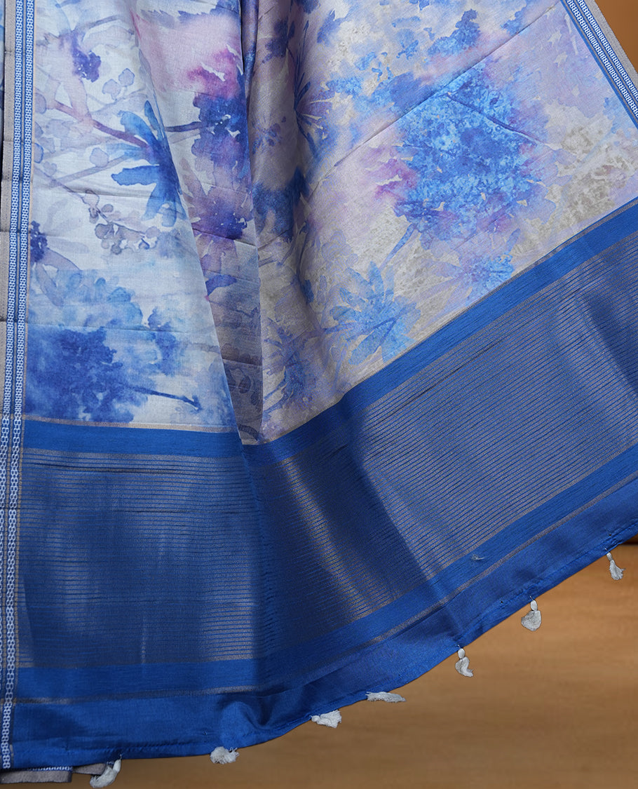 Royal blue colour semi tussar silk saree featuring an abstract digital floral printed body with a rich self border and tasselled pallu, paired with a matching blouse.
