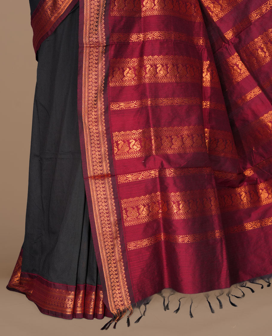 Black colour kalyani cotton saree featuring gold zari motifs on body, complemented by contrast maroon color with copper zari pattern border , paired with matching blouse piece.