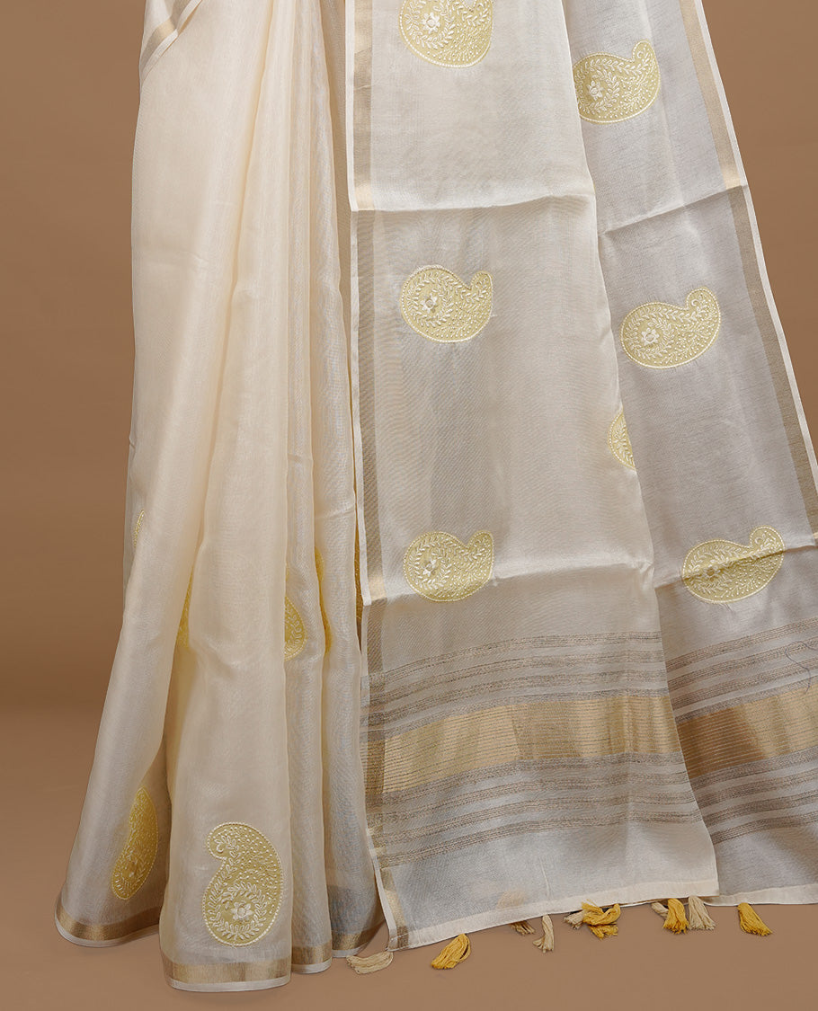 Cream colour Tussar saree featuring yellow colour Mango pattern with chikankari embroidery work, highlighting gold zari simple border, paired with matching unstitched blouse.