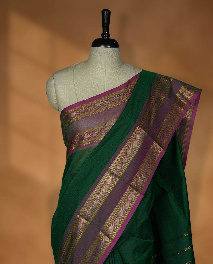 Dark green colour chettinad cotton saree featuring Elegant plain body, contrast Dusty Magenta colour border with gold zari border, pallu and paired with matching blouse.