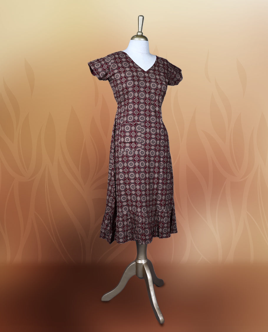 Classy maroon colour nightwear with intricate circular patterns in beige and black, Designed with a V neckline, short sleeves, and a flared hemline. Ideal for casual outings, workwear, or ethnic inspired looks.