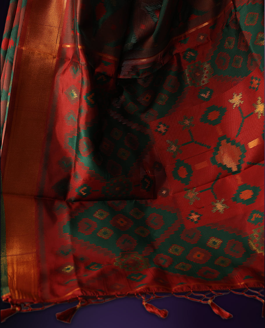 Maroon and green Ikat silk saree featuring intricate woven geometric and floral motifs across the body and pallu, complemented with a golden brown zari border and tassels, paired with a matching blouse piece.