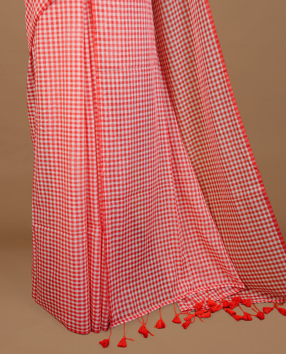 Red and White colour Mul Cotton saree featuring a classic small check pattern on the body, accented with tassels for added charm. Comes without a blouse piece.