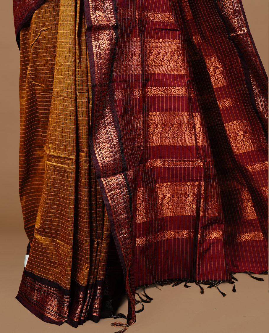 Mustard colour kalyani cotton saree featuring gold zari check pattern on body, highlighting contrast Maroon colour with Antique gold zari border, paired with matching blouse piece.